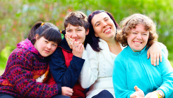 Photo of four friends smiling together.