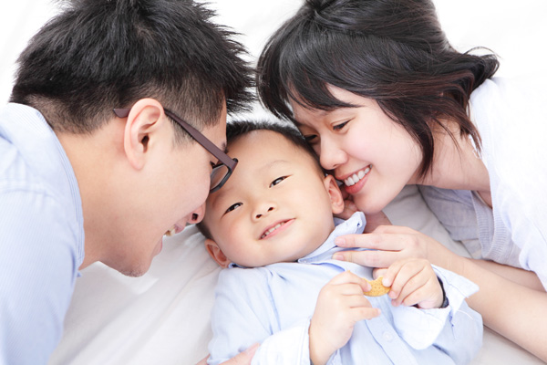 Photo of parents cuddling their child.