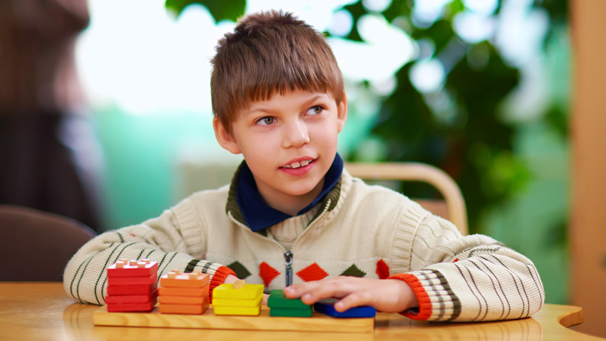Photo of a young boy playing with puzzle.