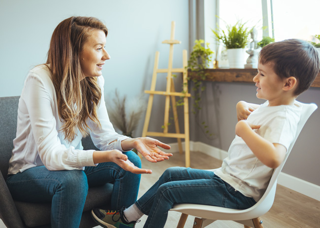 Photo of a clinician interviewing a smiling young patient.