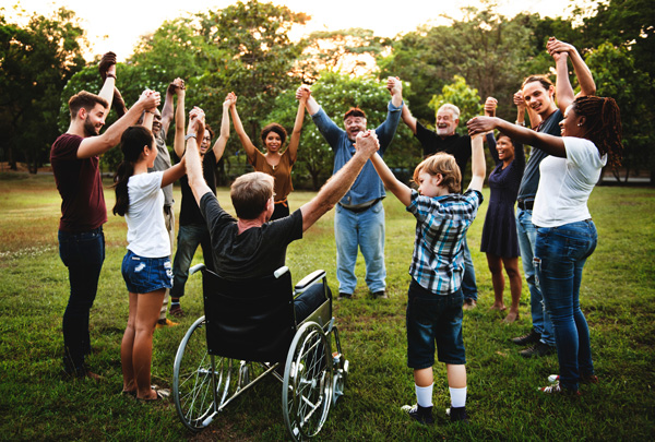 Photo: Group of people in a circle, smiling, and holding their hands up.