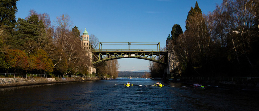 Photo of Montlake Bridge in Seattle with rowers paddling toward the bridge.