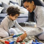 Photo of a mother and child working on a puzzle together.