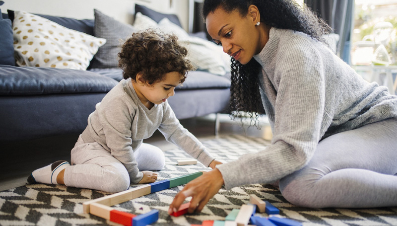 Photo of a mother and child working on a puzzle together.