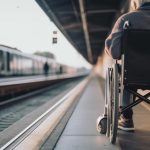 Photo: A man in a wheelchair waiting for a train - using mass transit.