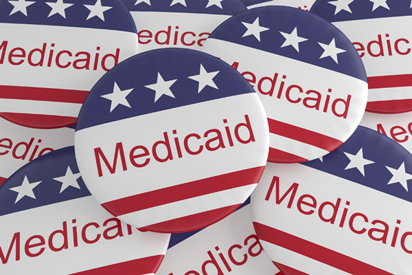 Image: US flag buttons with Medicaid typed in red on a white background