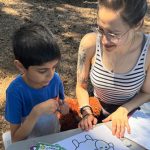 Photo: APEX Summer Camp counselor working on an art project with an APEX Summer Camp camper.