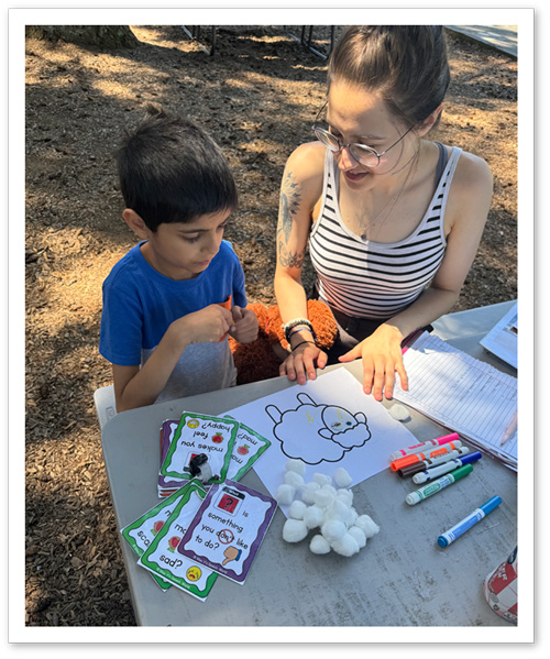 Photo: APEX Summer Camp camper working on a art project with a APEX Camp counselor.