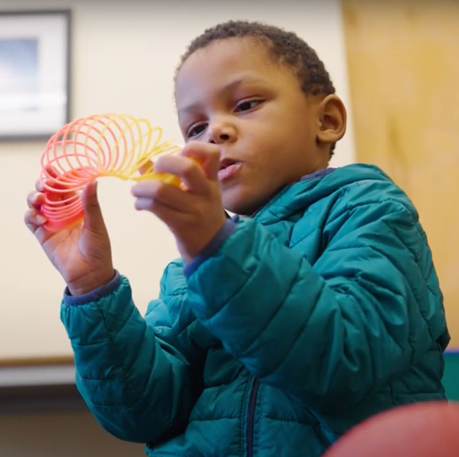 Child playing with a slinky in the IHDD.