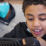 IHDD student using an assistive technology device.