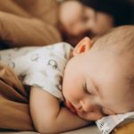 Baby sleeping next to mom.