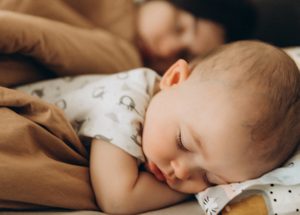 Baby sleeping next to mom.