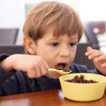 Young child eating cereal.