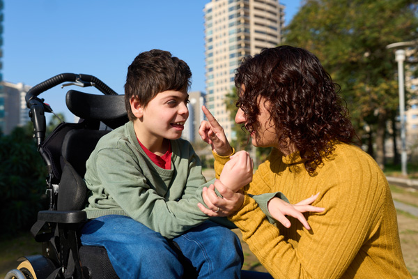 Happy child with Cerebral Palsy communicating with caregiver.