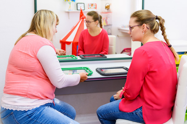 Instructor showing an adult how to use an AAC device.