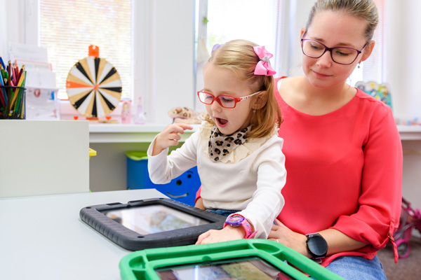 Young child with CP and parent using an assistive technology tablet. 