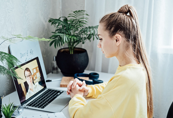 Woman looking at her laptop during a Zoom or ECHO video call.