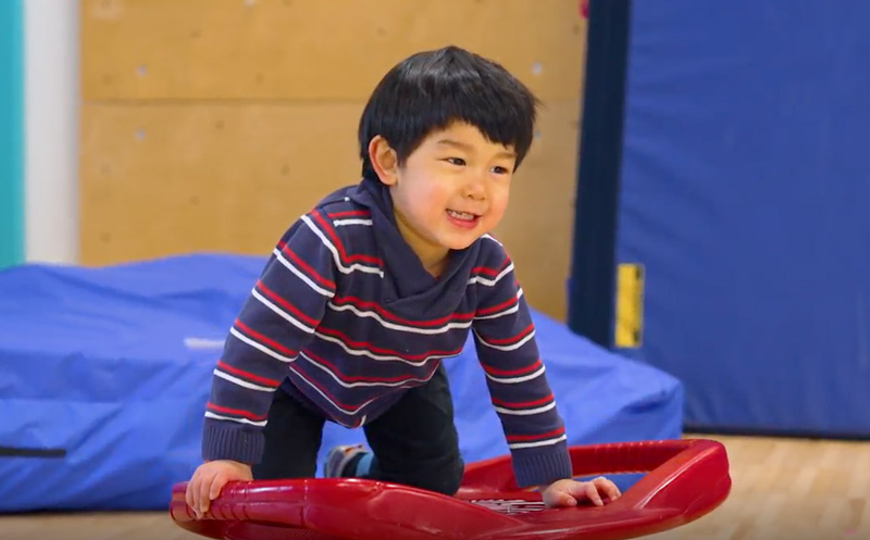 Young child smiling and playing in Haring Center.