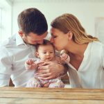 Young couple holding their baby.