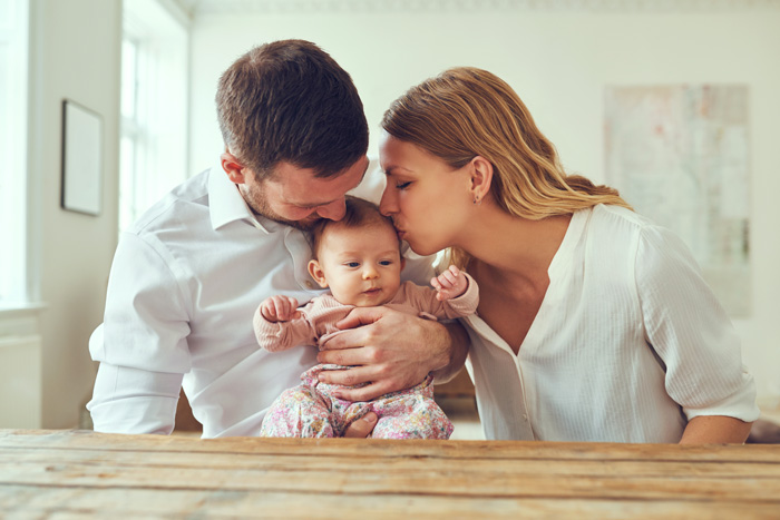 Young couple holding their baby.