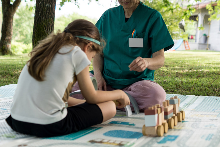 Child sitting with clinician running growth and stimulation tests.
