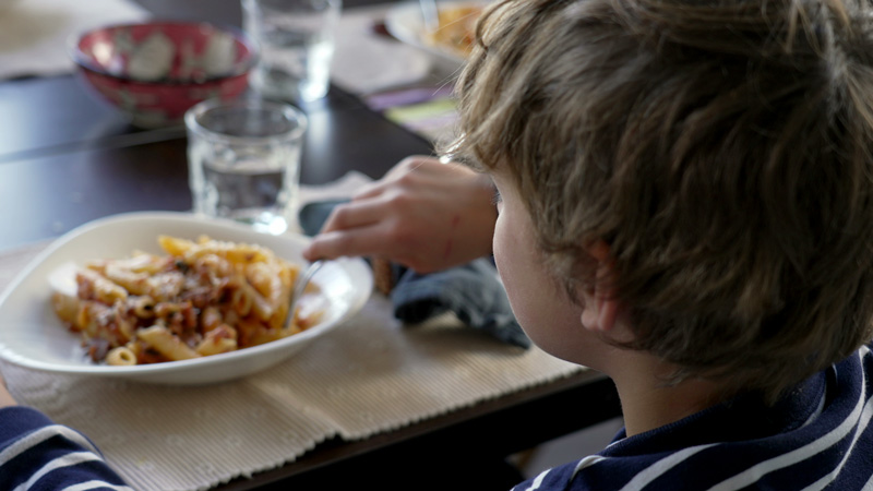 Child eating bowl of pasta.