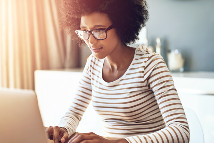 A woman completing a survey on her computer.